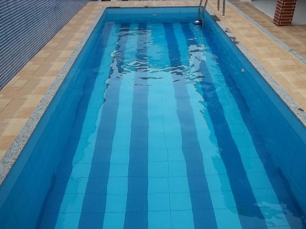 una piscina vacía de agua azul en Casa de Veraneio, en Cabo Frío