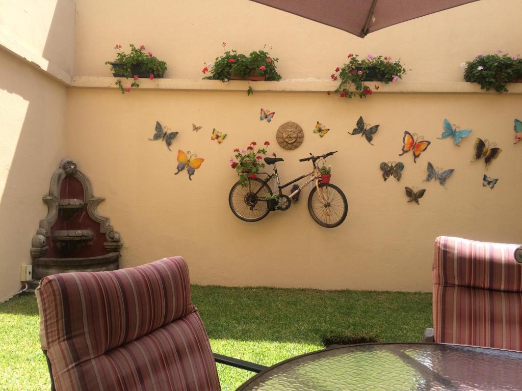 ein Fahrrad hängt an einer Wand mit Schmetterlingen in der Unterkunft Hostal Los Lagos Inn in Guatemala