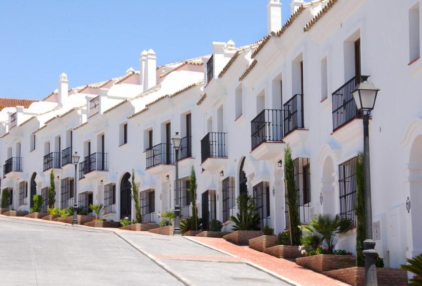 a row of white houses with balconies on a street at Casares Village Bed & Breakfast in Casares