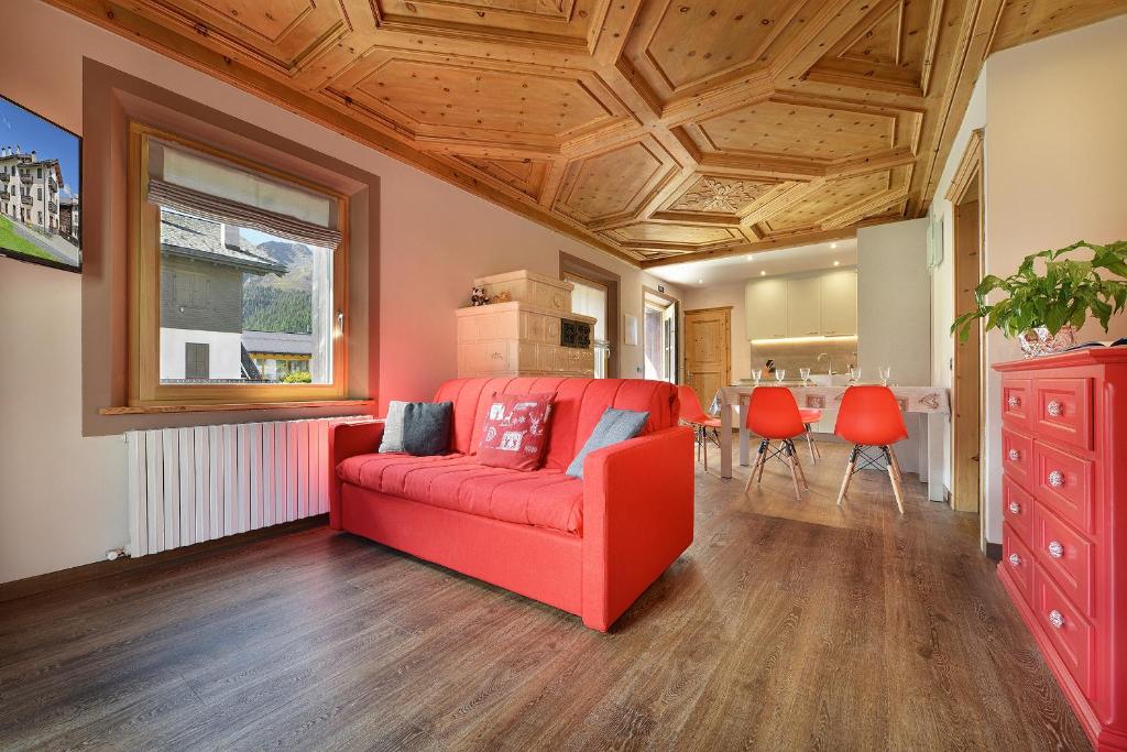 a living room with a red couch and a table at Chalet Goloseria in Livigno