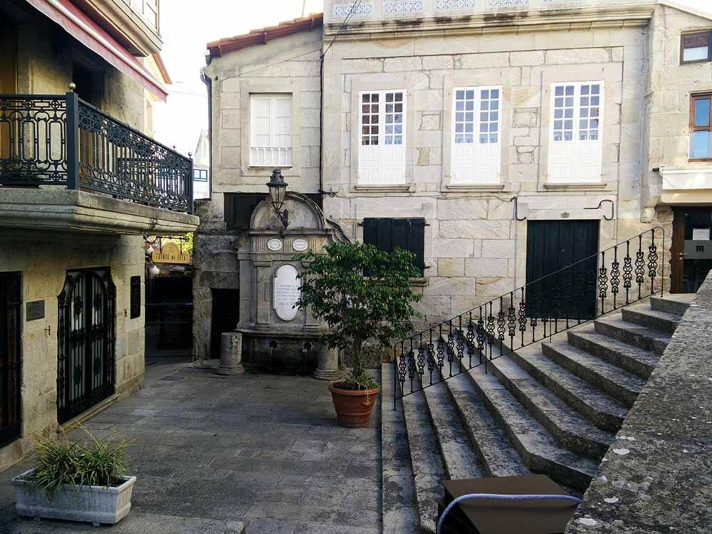 a building with a fence and a tree in front of it at Fonte Zeta in Baiona