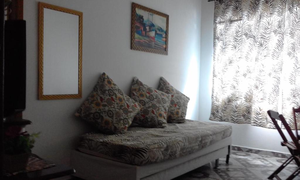 - un canapé avec des oreillers dans l'établissement apto 1 quarto, Boqueirão Praia Grande, à Praia Grande