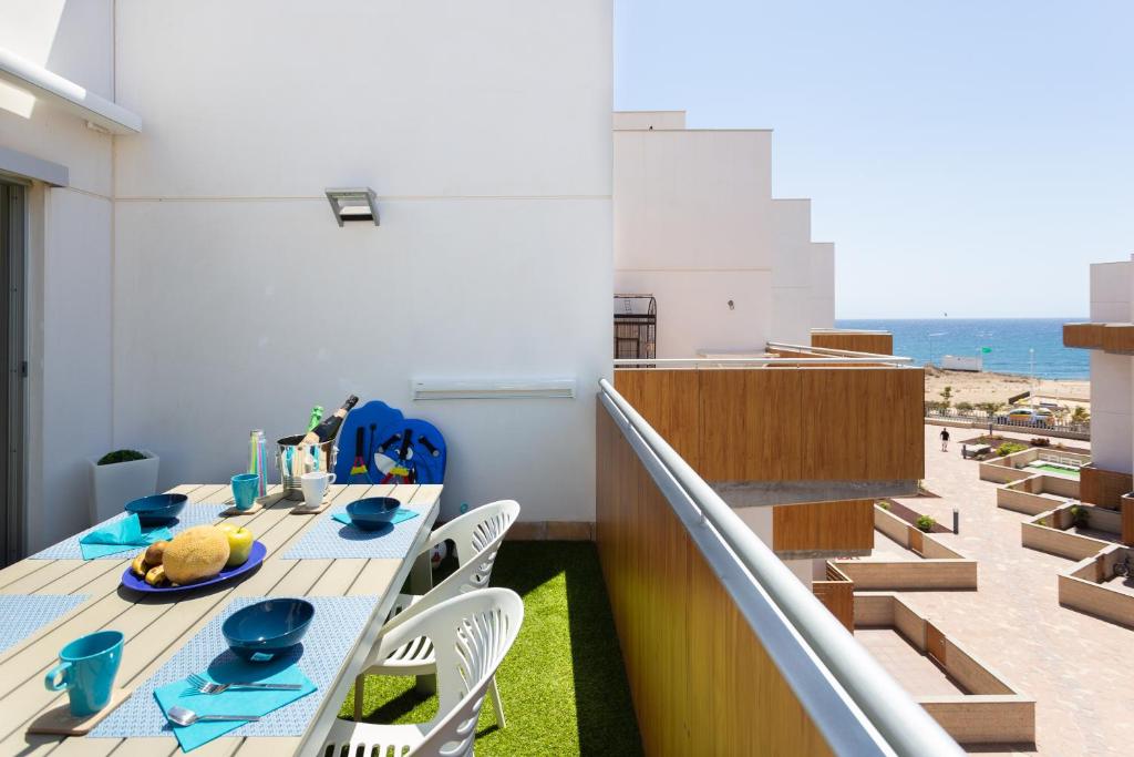una sala da pranzo con tavolo e sedie e la spiaggia di Luxury beachfront penthouse a El Médano