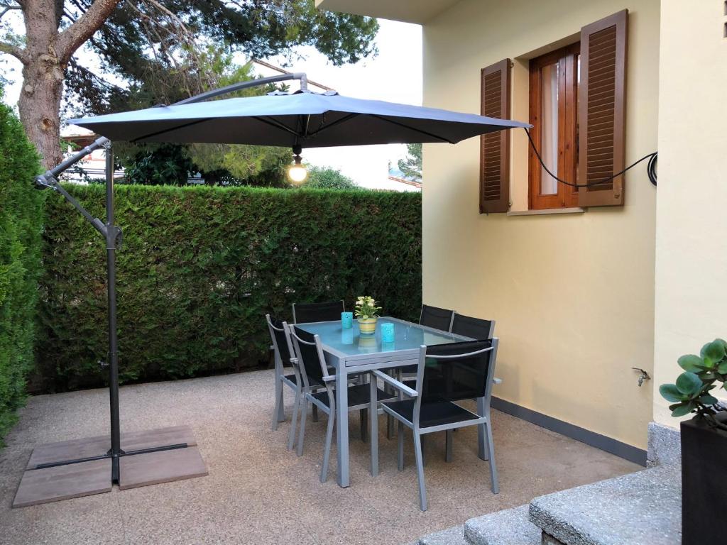 a table and chairs under an umbrella on a patio at Casa Coromines in Alcudia