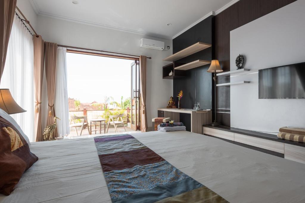 a bedroom with a large bed with a large window at Villa Melasti Wardana in Uluwatu