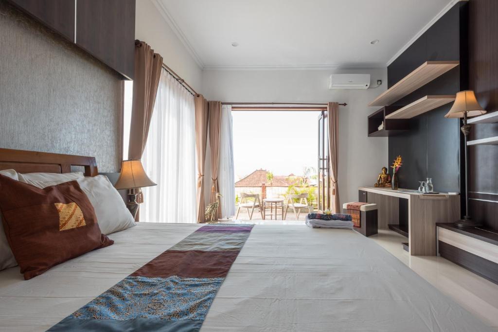 a bedroom with a large bed with a large window at Villa Melasti Wardana in Uluwatu