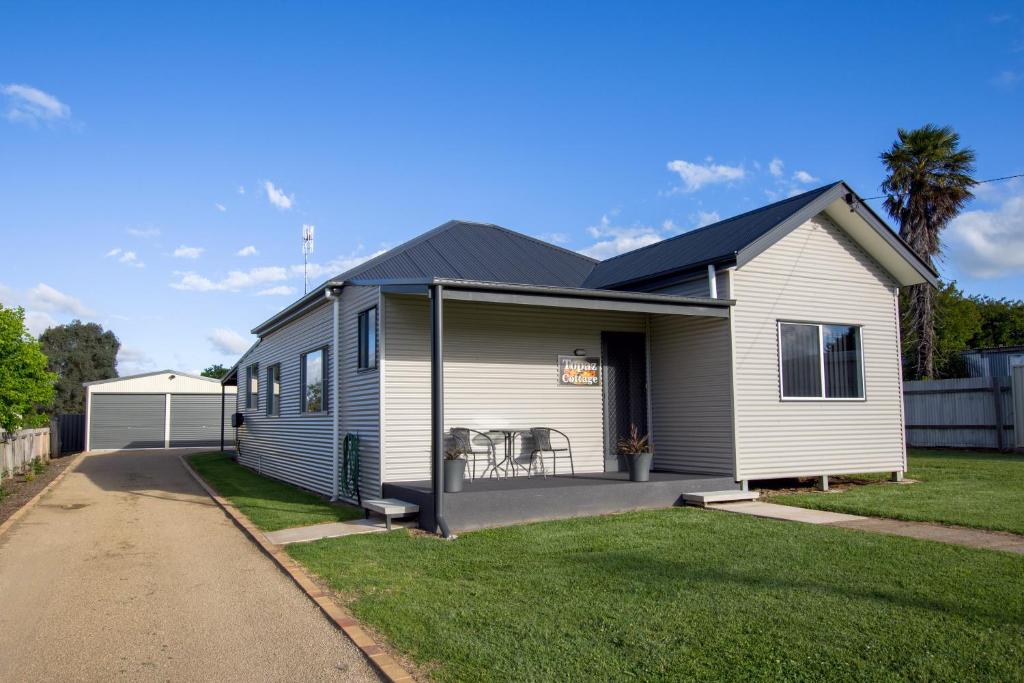 a white house with a black roof at Topaz Cottage in Glen Innes