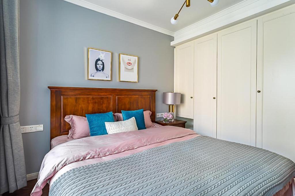 a bedroom with a large bed with pink and blue pillows at Changsha Yuelu·Meixi Lake· Locals Apartment 00165310 in Changsha