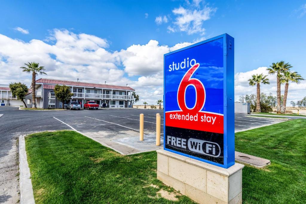 een bord op een parkeerplaats voor een gebouw bij Studio 6-Buttonwillow, CA in Buttonwillow