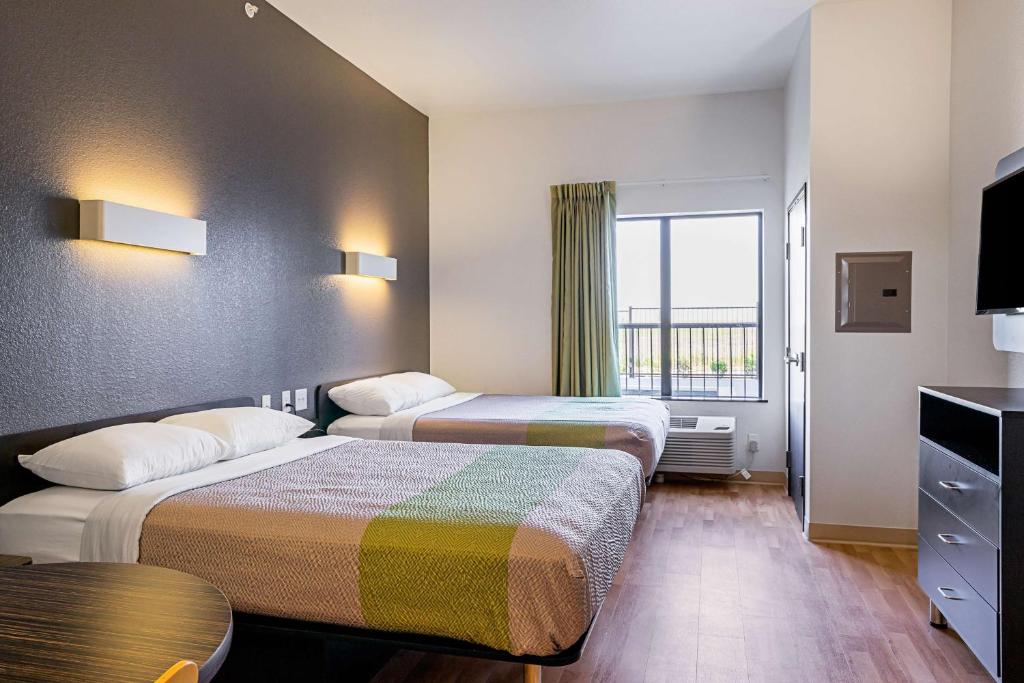 Una habitación de hotel con dos camas y una ventana. en Studio 6-Buda, TX, en Buda