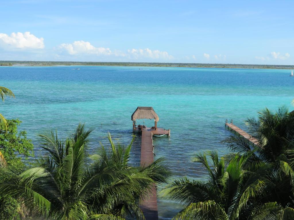 a dock in the middle of a large body of water at Amigos Hotelito in Bacalar