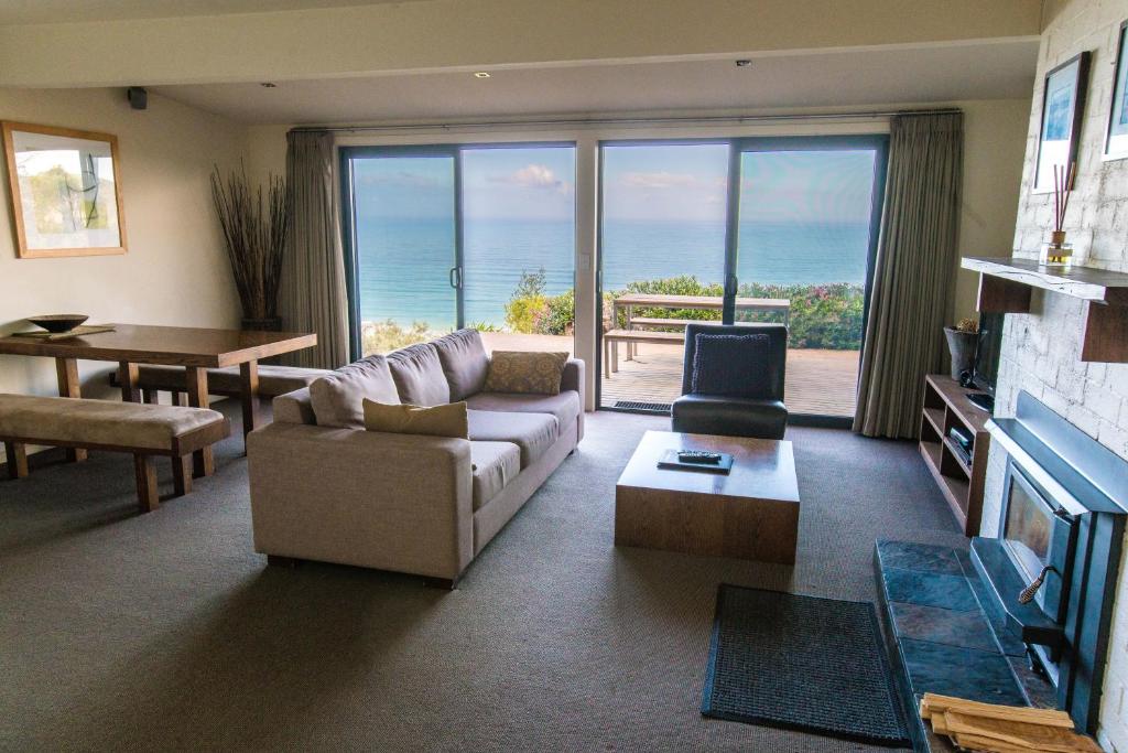 a living room with a couch and a table at Beacon Point Ocean View Villas in Apollo Bay