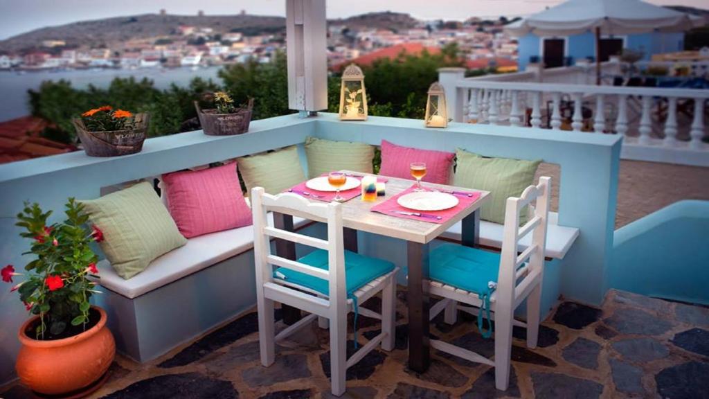 a small table and chairs on a balcony with a view at Amazing House in Halki in Halki