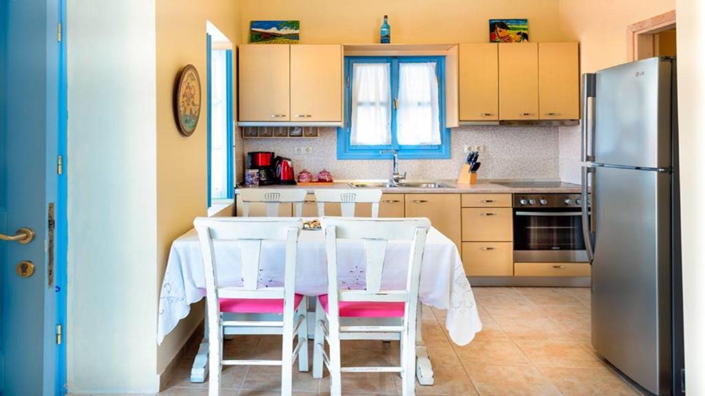 a kitchen with a table with chairs and a refrigerator at Amazing House in Halki in Halki