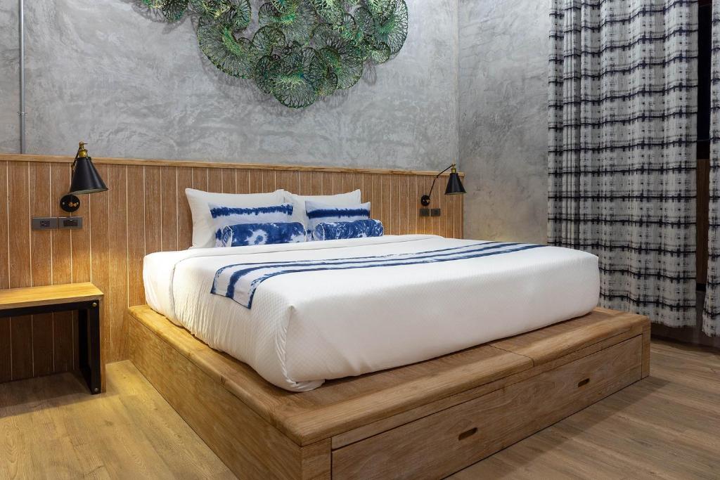 a bedroom with a large bed with blue pillows at The Chic Lipe in Ko Lipe