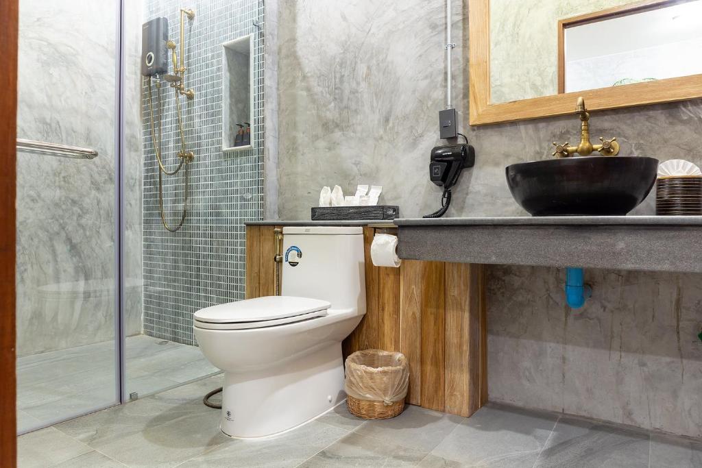 a bathroom with a toilet and a sink and a shower at The Chic Lipe in Ko Lipe