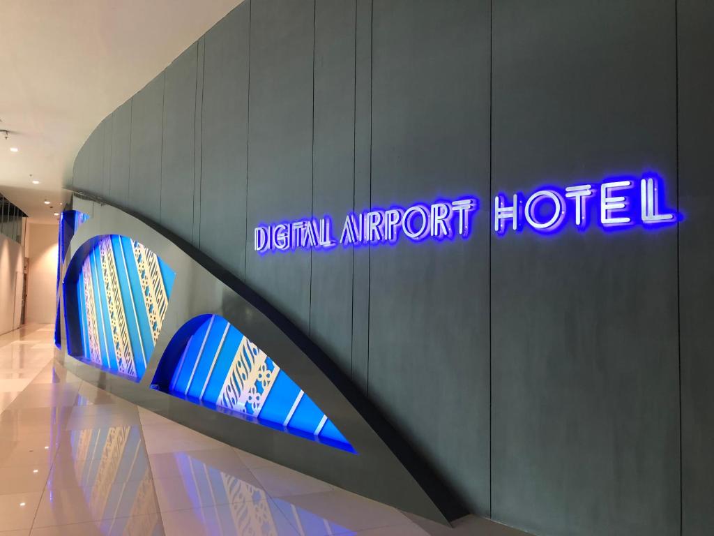 a sign for a hotel with surfboards on a wall at Passgo Digital Airport Terminal 3 Soekarno Hatta in Tangerang