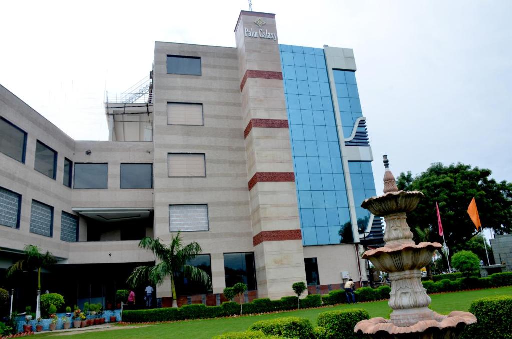 a building with a fountain in front of it at Palm Galaxy in Itimādpur