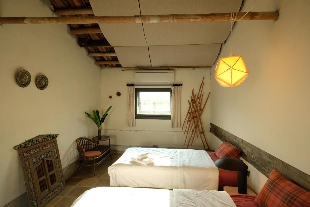 a bedroom with two beds and a window at Yellow And Black Guest House in Meinong