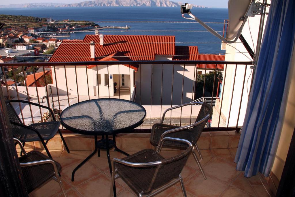 una mesa y sillas en un balcón con vistas al agua en Apartment Mira, en Senj