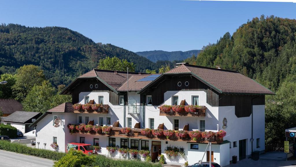 ein Hotel in den Bergen mit Blumen auf den Balkonen in der Unterkunft Hotel - Pension Scheiblechner in Göstling an der Ybbs