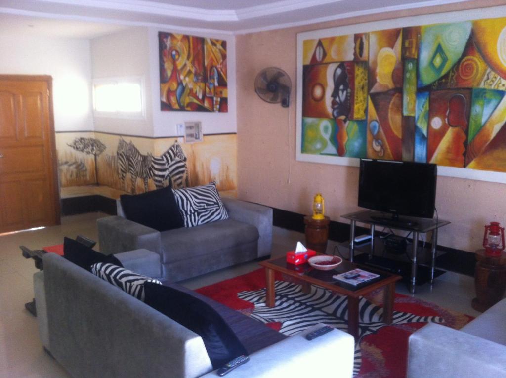 a living room with a couch and a tv at Residence Les Calanques in Dakar