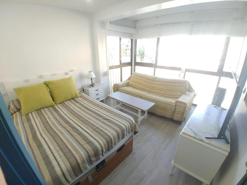 アルムニェーカルにあるApartamento Caléndulaの小さなベッドルーム(ベッド2台、ソファ付)