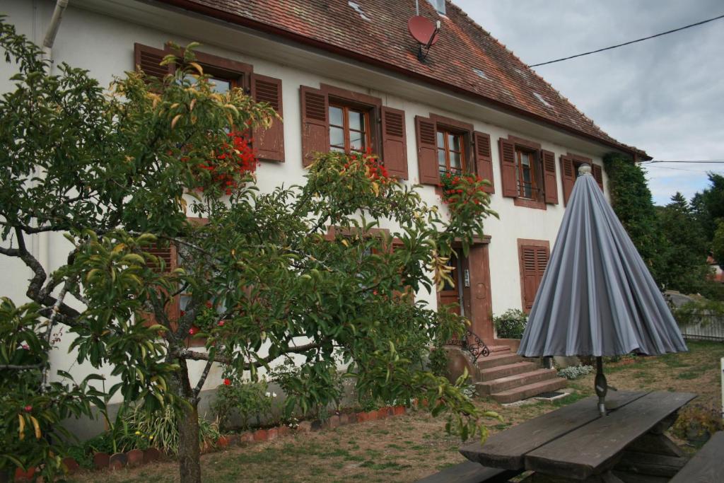 un paraguas sentado en una mesa frente a una casa en Maison d'Alsace, en Breitenbach-Haut-Rhin