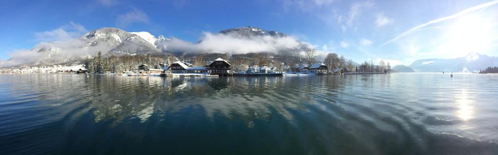 una gran masa de agua con casas y una montaña en Arndt's Bootshaus, en St. Wolfgang