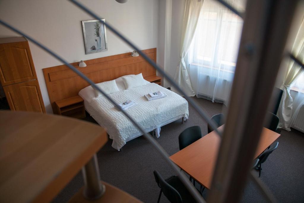 Zimmer mit einem Bett, einem Tisch und Stühlen in der Unterkunft Café Kaftan - pension in Kolín