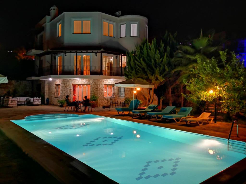 a house with a swimming pool at night at Villa Ekinoks in Kalkan
