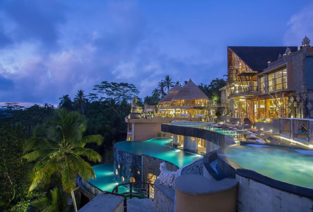 a resort with a pool at night at The Kayon Jungle Resort in Ubud