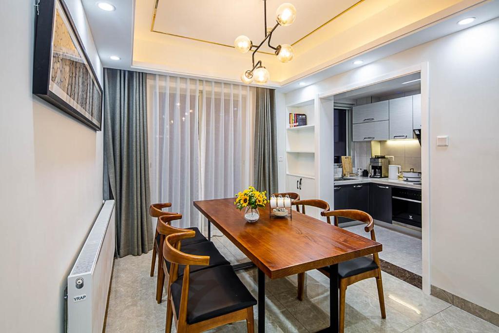 cocina y comedor con mesa de madera y sillas en Changsha Kaifu·Beichen Delta· Locals Apartment 00150040, en Changsha
