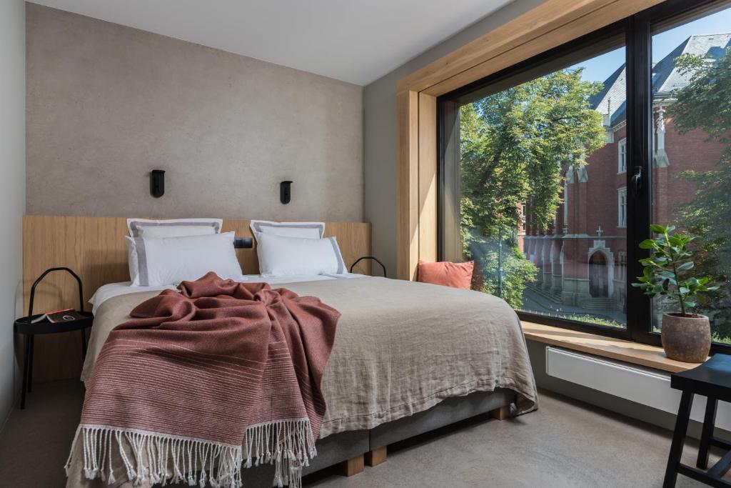 a bedroom with a bed and a large window at Academia Apartments in Krakow