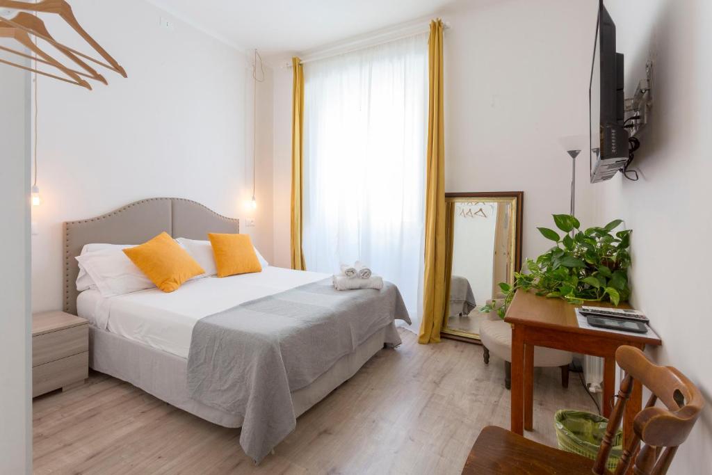 een slaapkamer met een bed, een bureau en een raam bij Hotel Cathrine in Rome