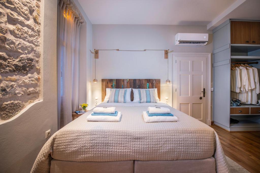 um quarto com uma cama grande com duas almofadas em The "Fan" studio in the heart of Old Corfu Town em Corfu Town