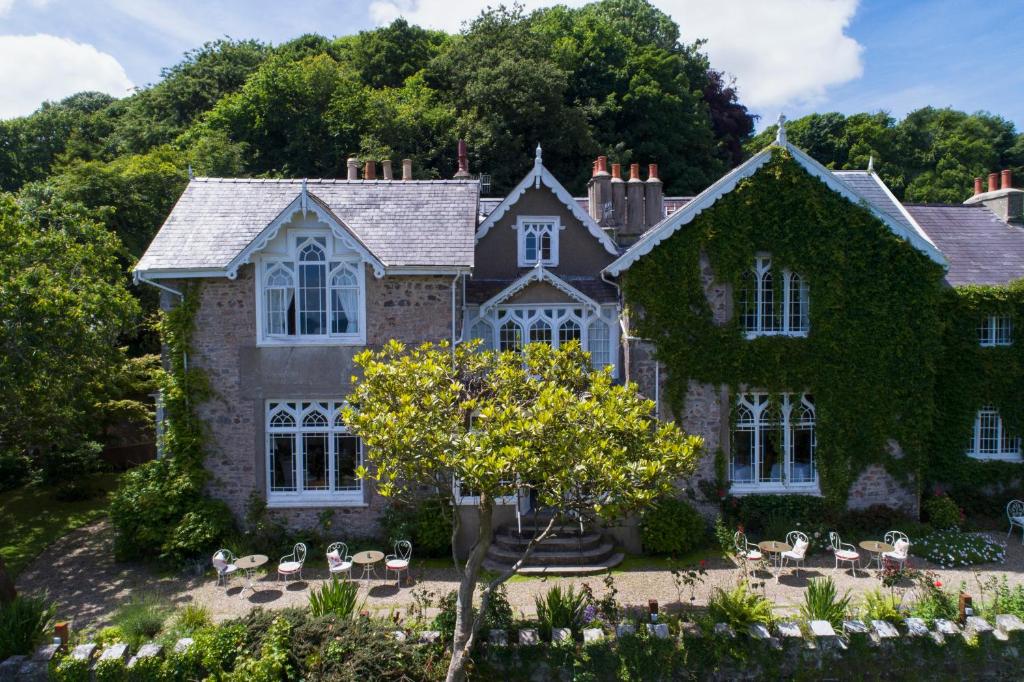 an old stone house with ivy at Penally Abbey Country House Hotel and Restaurant in Tenby