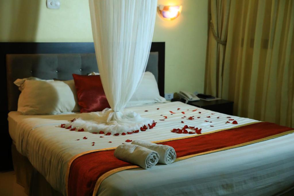 a bed with red rose petals on it at Lakemark Hotel and Tour Service Bahir Dar in Bahir Dar