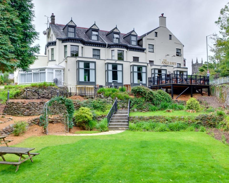 a large white house with a lawn in front of it at Anglesey Arms Hotel in Menai Bridge