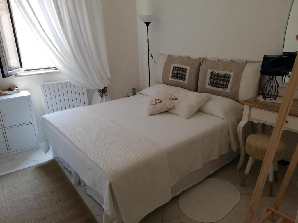 a bedroom with a white bed and a window at Il Vicolo di Ripa B&b in Ripatransone