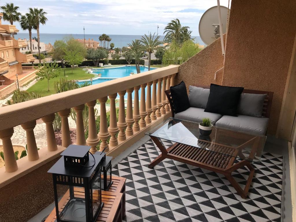 een balkon met een bank, een tafel en een zwembad bij Campello Mistral in El Campello