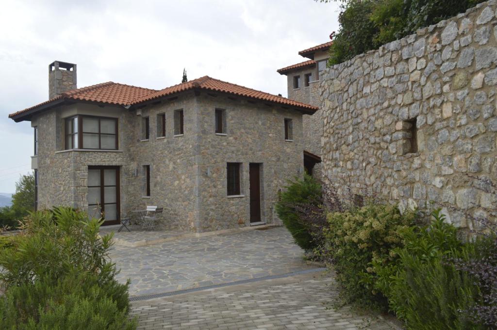 a large stone building next to a stone wall at Sansa Stark Chalet in Arachova