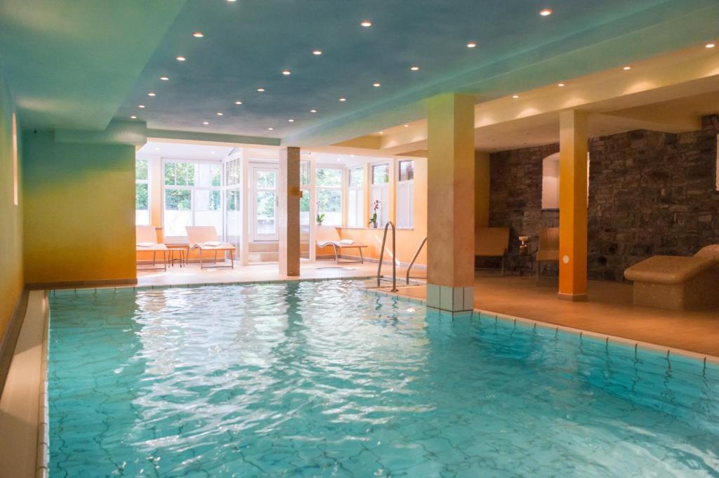 a large swimming pool in a hotel lobby at Boutiquehotel Schloßpalais in Wernigerode