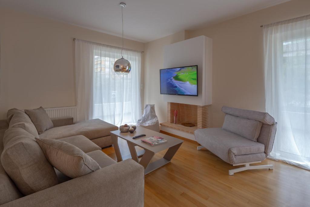 a living room with a couch and two chairs and a table at Sagittarius - Faliro Sea Side apartment in Athens