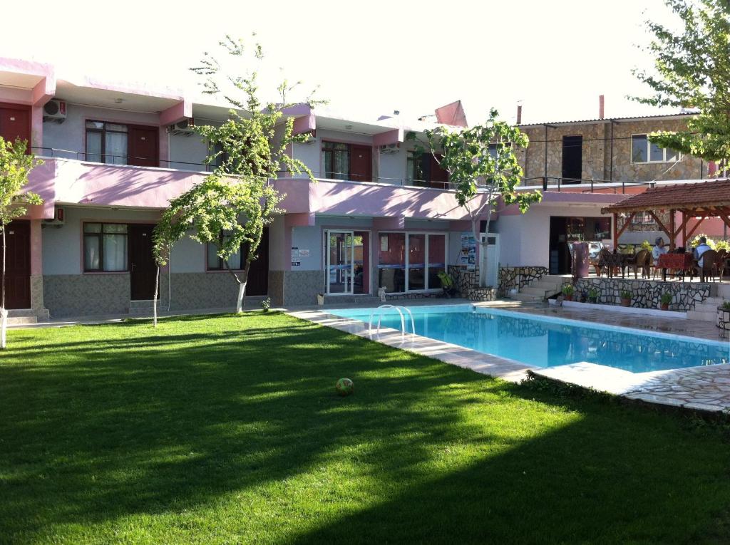 a yard with a swimming pool in front of a building at Sunrise Aya Hotel in Pamukkale