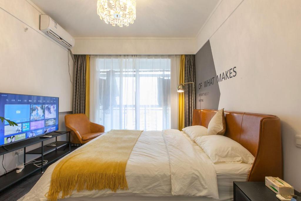a bedroom with a large bed and a television at Wuhan Jianghan·Zhongshan Park· Locals Apartment 00157640 in Wuhan