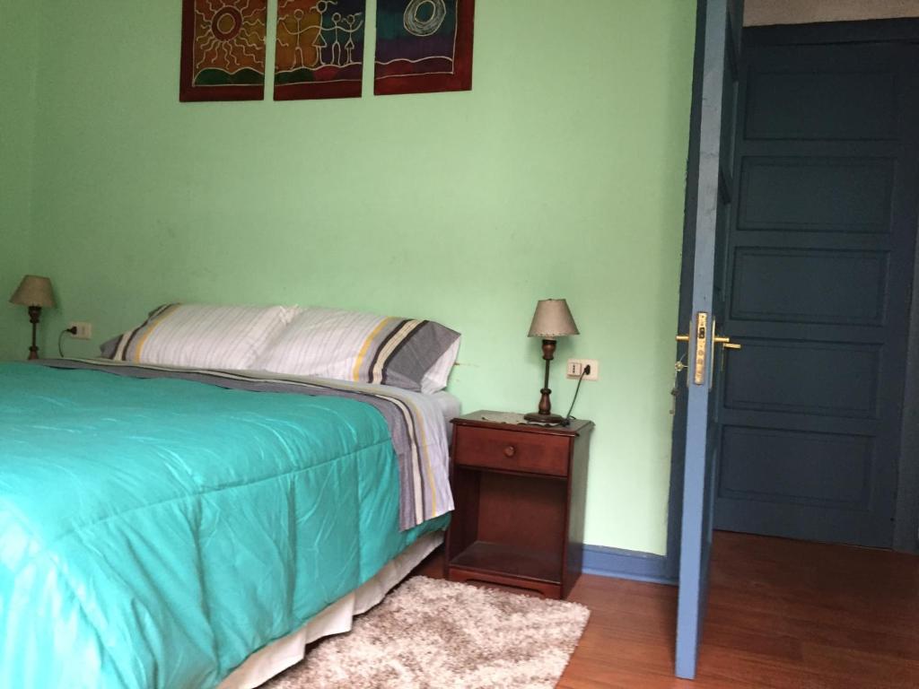 een slaapkamer met een bed en een tafel met een lamp bij Casa conferencia in Santiago