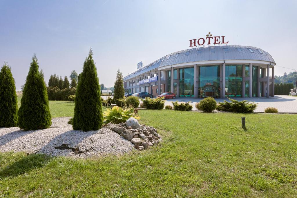 a hotel with a large building in a park at Hotel Sezam in Machowa