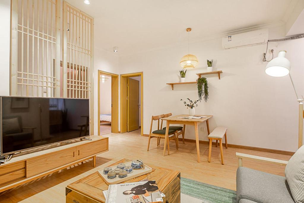 un soggiorno con grande TV e tavolo di Changsha Furong·Changsha Railway Station· Locals Apartment 00159160 a Changsha