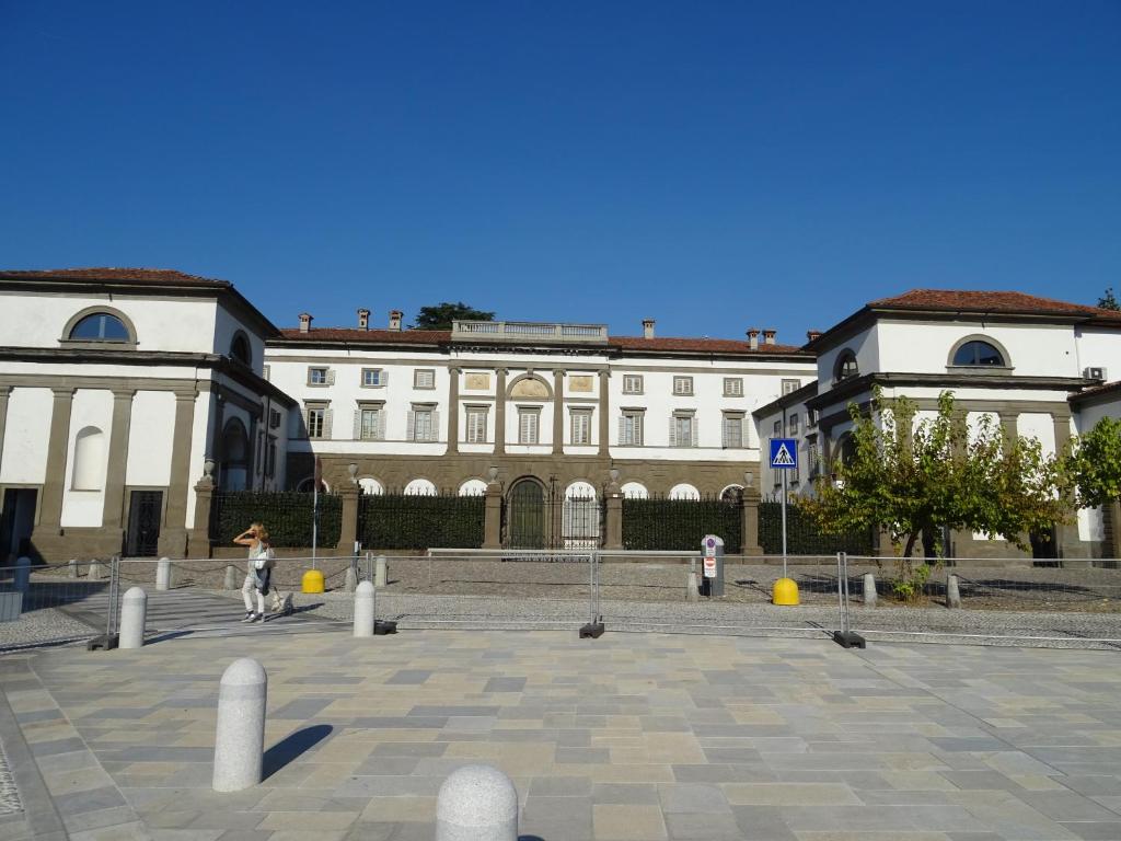 une personne marchant devant un grand bâtiment dans l'établissement CharmeRooms Villa Moroni, à Stezzano